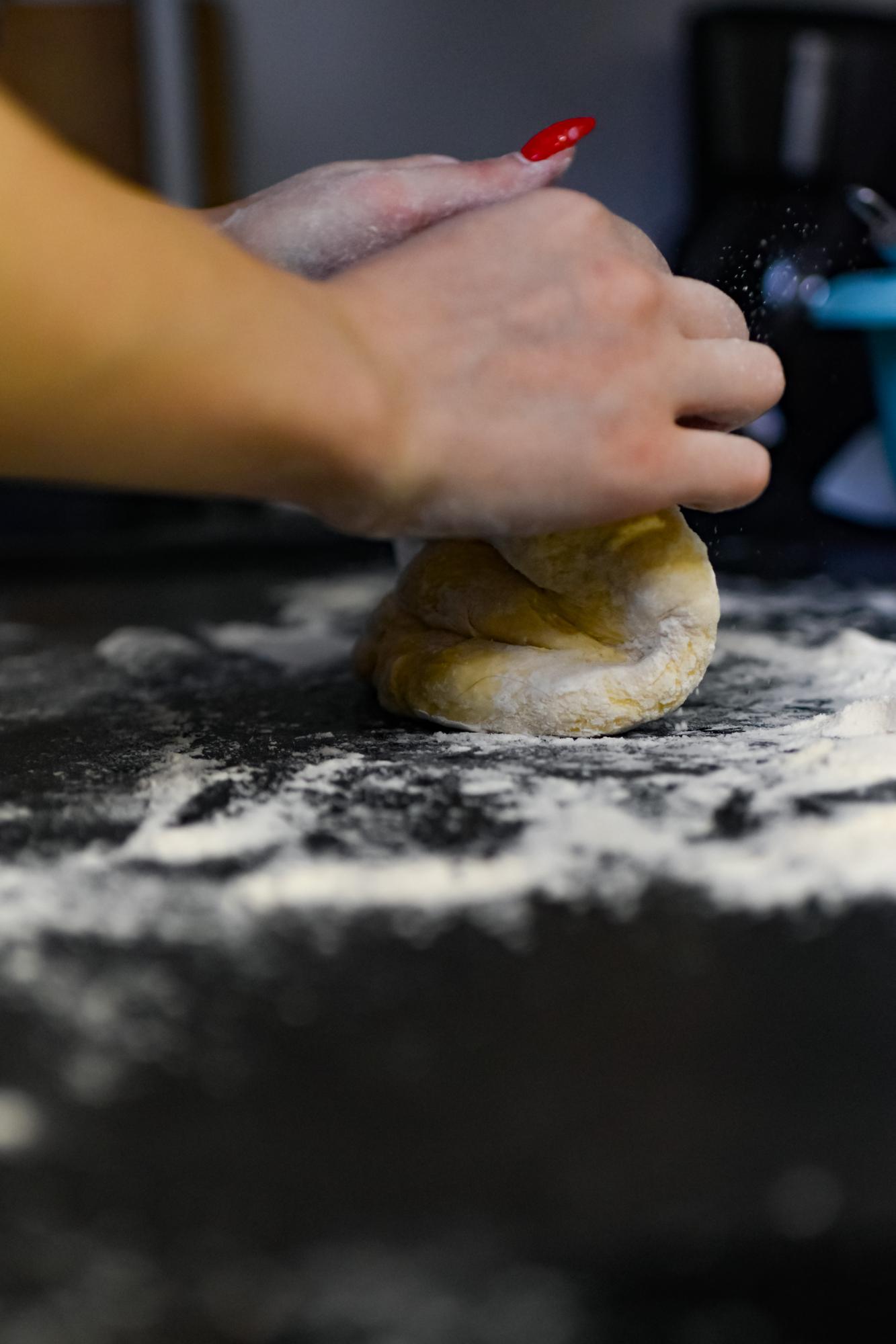 Close-up hands shaping dough